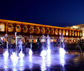 Multicolored fountains against the beautiful architectural building in Lodz