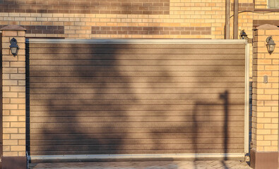 Modern wooden gate in sunlit brick wall setting for home security and privacy design