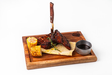 Grilled pork ribs with corn and sauce on board