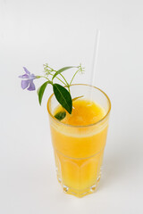 Fresh orange juice in glass with flower garnish