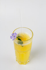 Refreshing yellow drink serving with flower garnish