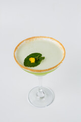 Elegant green cocktail presenting sugared rim and flower garnish