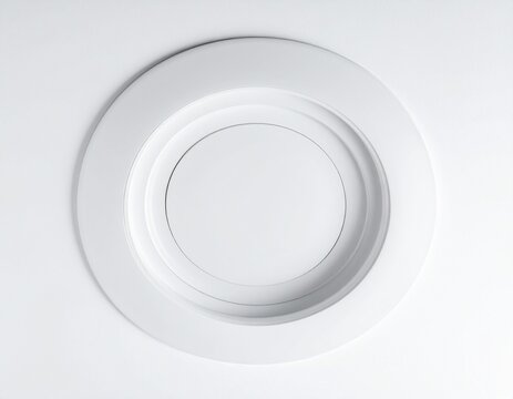 White recessed light fixture installed in a ceiling with concentric circles