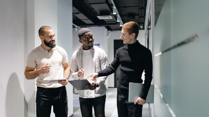 Diverse Business Team Walking and Discussing New Project in Modern Office Hallway