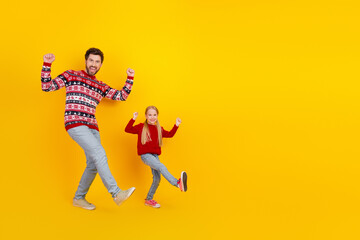 Single father and daughter celebrating Christmas together on a bright yellow background showcasing festive spirit and winter joy
