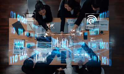A group of professionals engaging in collaborative data analysis surrounded by digital graphs and charts, highlighting teamwork and modern business strategies in a dynamic office setting. Trope
