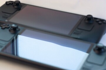 Two portable gaming devices (game consoles) side by side: a comparison of design, ergonomics, and functionality for tech reviews, gaming blogs, and digital products