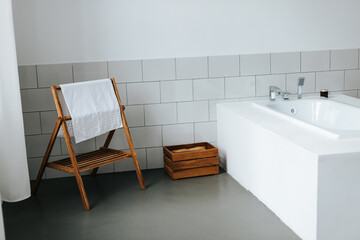 Bathtub, Wooden Towel Rail in white interior of bathroom