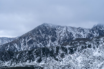 Obraz premium Snow-Capped Mountain Peaks Hidden in Misty Fog