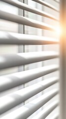 Sunlight filtering through white window blinds creating a soft glow