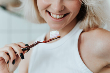 Close up view on toothbrush with toothpaste in smiling blonde woman hand