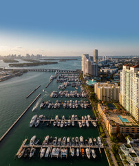 Aerial view of Miami beach with luxury yachts and tropical skyline. Coastline Miami waterfront. Sailboats and yachts in a calm marina and turquoise ocean. Luxury cruise ship.
