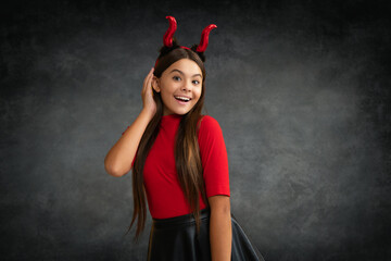Girl with devil horns. Halloween witch girl. Little kid witch. Kid girl witch celebrates Halloween. Happy Halloween. Portrait of an Halloween child teen girl.