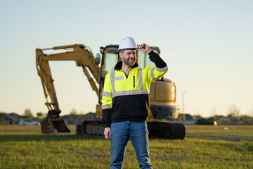 Builder with excavator for construction at the construction site. Machinery tractor with builder at buildings background. Excavator builder worker. Builder with helmet on construction site.