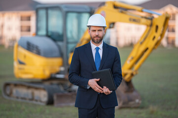 Worker in suit and helmet. Investor civil engineer, construction manager. Construction building developer at a construction site. Successful architect. Handsome hispanic builder man in suit.