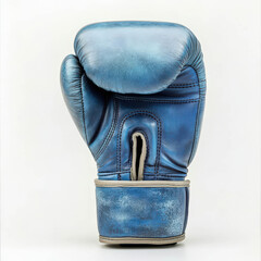 Boxing glove resting on a neutral background emphasizes its worn texture and blue color, showcasing the sport's rugged nature and the athlete's dedication to training and competition