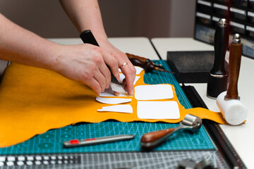 Leather crafting with precision knife and templates. Leather Cutting with Knife and Templates. Artisan cuts premium leather with sharp knife and paper templates.