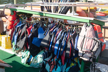 Safety vests organized on a rack at the marina for water activities