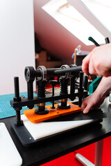 Leather pressing provides strength and detail to handmade designs, creating premium results for wallets, belts, and accessories. Craftsman uses press machine to imprint patterns into leather.