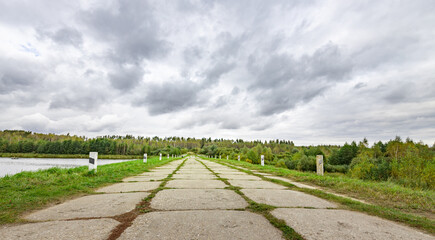 Long, empty road with a few trees in the background