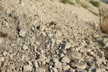 Light colored rough textured rock debris pile with crushed stones and gravel material