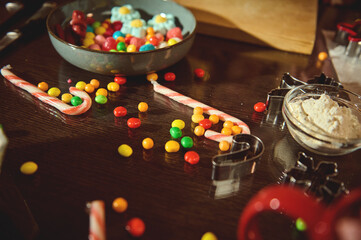 Sweet Christmas Baking Scene With Candy Canes, Colorful Candies, Flour, And Cookie Cutters On A Wooden Table