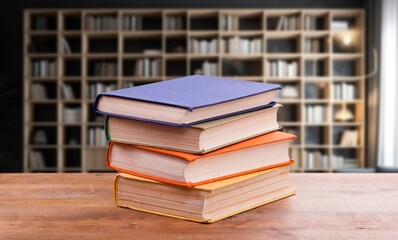stack of reading books on desk in library
