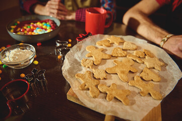 Family Cookies Night: Gingerbread Figures, Dough, Cutters, and Colorful Candies on a Wooden Table