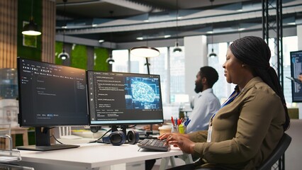 Female software developer using artificial intelligence to optimize performance and forecast issues. Woman in office training machine learning models using computer, camera A