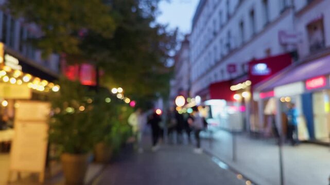 Enjoy a vibrant evening stroll along a lively city street featuring cozy outdoor dining options to savor