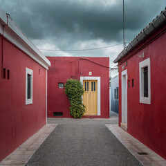 View of vibrant red walls embracing a narrow cobblestone street, adorned with potted plants and vintage lanterns, creating a captivating scene, Arequipa, Peru.