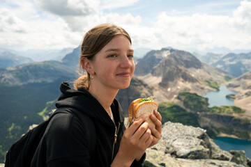 Woman enjoying a sandwich with mountain view