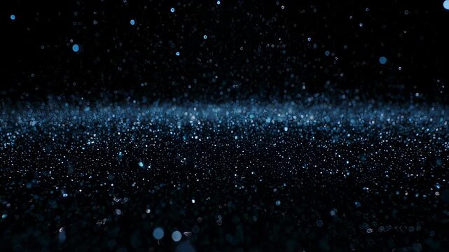 Dark image with sparkling blue droplets dispersed throughout the frame, creating a glowing effect