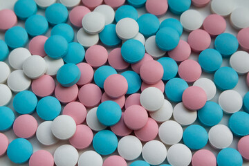 White, blue and pink tablets scattering on the table
