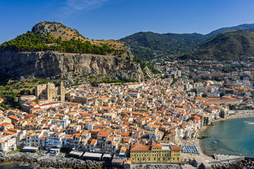 Naklejka premium Aerial drone view of Cefalu historic medieval old town with cathedral beach and turquoise Tyrrhenian Sea in summer on northern coast of Sicily island southern Italy Europe Mediterranean destination