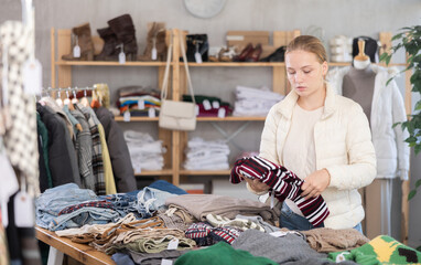 Seasonal trade sale, young woman girlie search and choose autumn pullover, pick up some wardrobe items. Discount season, promotional offers. Modern urban casual fashion