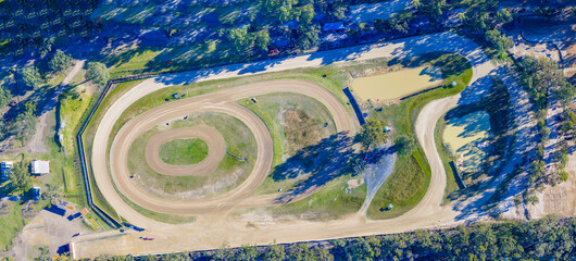 Drone aerial panoramic photograph of the Nepean Raceway speedway dirt track surrounded by trees and bushland in the greater Penrith region of NSW, Australia.