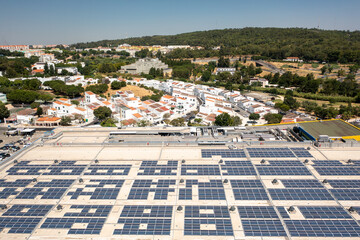 Aerial drone shot of solar panels installed on rooftop of shopping mall harnessing solar energy for electricity generation promoting sustainable and eco-friendly