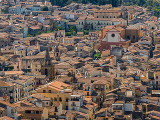 Aerial drone view of Castelbuono medieval town in the Madonie Mountains, Sicily, Italy, basking under the summer sun with historic streets, Ventimiglia Castle. Old mountain town in Sicily