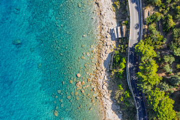 Aerial drone view of Scalette Beach in Cefalu, Sicily, Italy. the Tyrrhenian Sea, Capo Cefalu Lighthouse, rocky cliffs, Cefalu Harbor, and medieval castle ruins with scenic coastline panorama