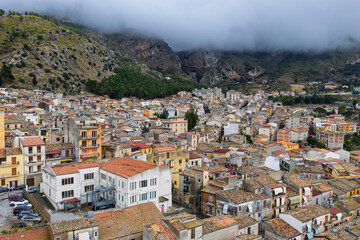 Aerial drone view of Collesano Sicilian mountain town at sunset with Basilica San Pietro church and historic stone streets in the Madonie Mountains, Sicily, Italy. Old mountain town in Sicily