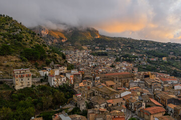 Obraz premium Aerial drone view of Collesano Sicilian mountain town at sunset with Basilica San Pietro church and historic stone streets in the Madonie Mountains, Sicily, Italy. Old mountain town in Sicily