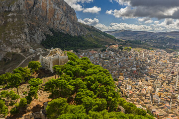 Obraz premium Aerial drone view of Caltavuturo, a historic Sicilian mountain town in Palermo, Italy, featuring its medieval castle, rugged surrounding cliffs, and scenic landscapes of the Madonie Mountains