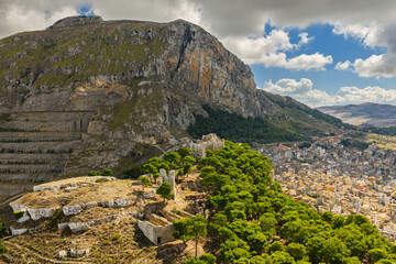 Obraz premium Aerial drone view of Caltavuturo, a historic Sicilian mountain town in Palermo, Italy, featuring its medieval castle, rugged surrounding cliffs, and scenic landscapes of the Madonie Mountains