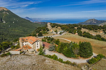 Aerial drone view of Piano Zucchi, a historic Sicilian mountain village at 1100 meters above sea level, surrounded by dense oak forests in the heart of Madonie Park, Isnello, Sicily, Italy