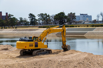 川岸で作業をする油圧ショベル