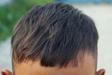 Fototapeta premium men's haircut with uneven or poorly cut bangs, showing the front of the hair being cut too short and asymmetrical