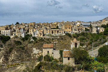 Fototapeta premium Aerial drone view of Polizzi Generosa, a picturesque Sicilian mountain town perched on rocky cliffs showcasing traditional stone buildings and panoramic views of the Madonie Mountains, Sicily, Italy