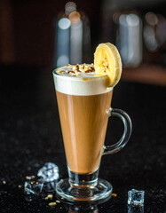 A glass of coffee with a banana slice on top