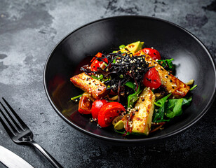 A black bowl filled with a salad